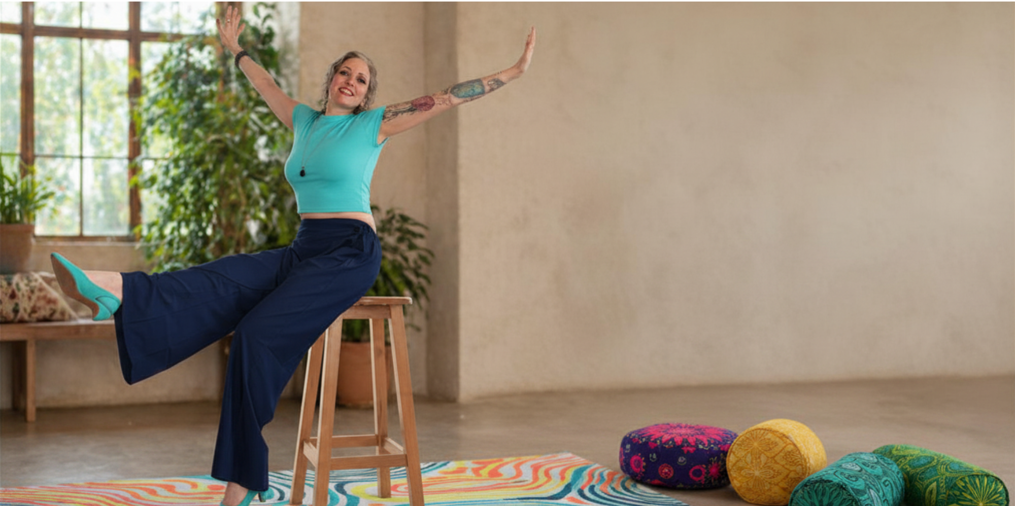 Heather McDonald balanced playfully on a stool with arms outstretched, living lighter after rebuilding how she operates