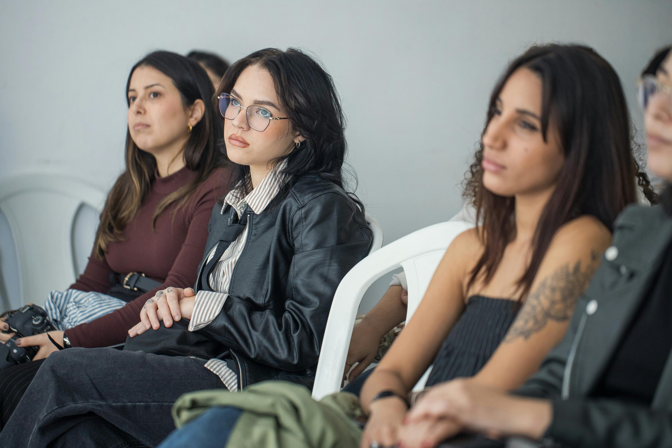 Professional women seated and listening attentively, the kind who would never describe themselves as overwhelmed out loud