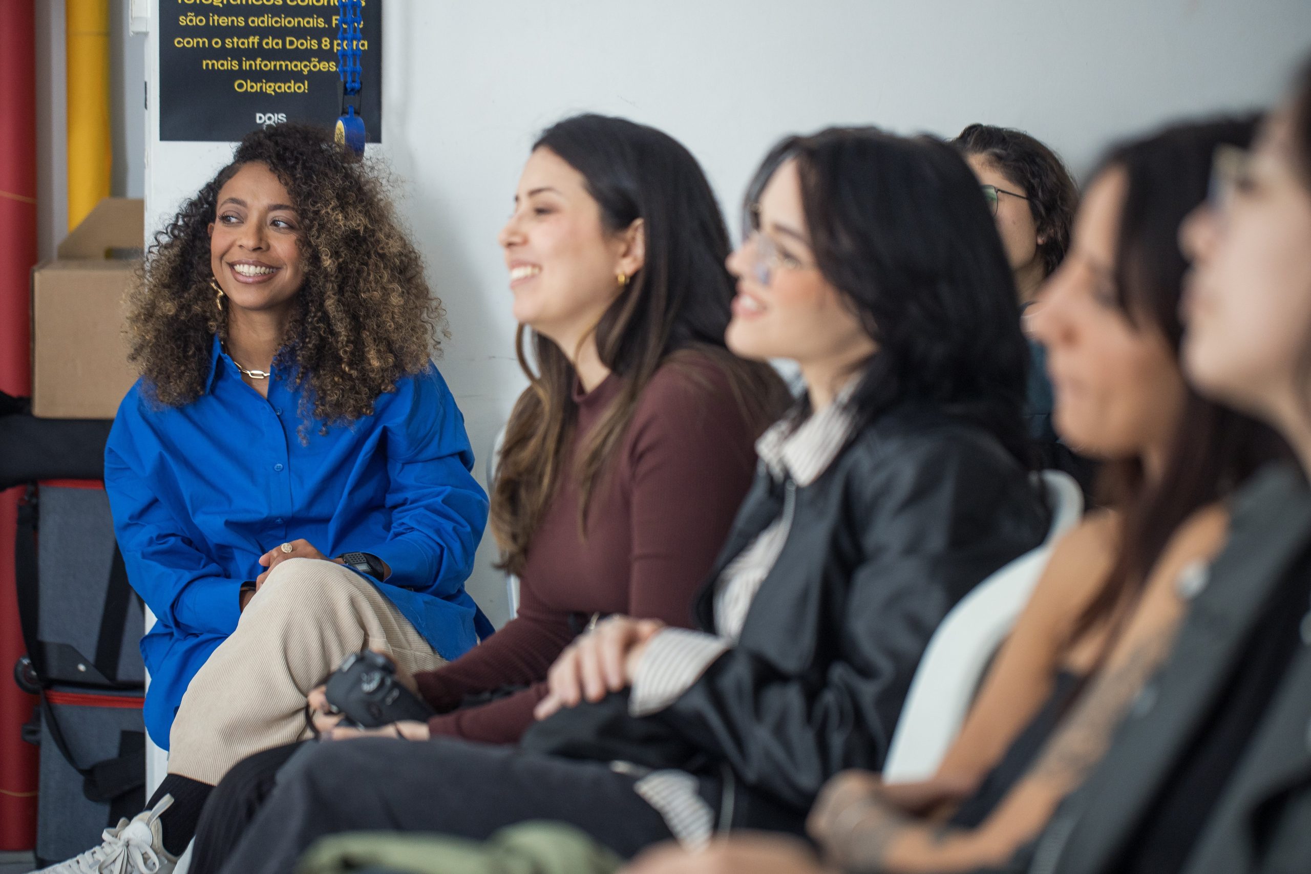 A row of women smiling and engaged during a talk, leaving with language and clarity rather than a week of inspiration