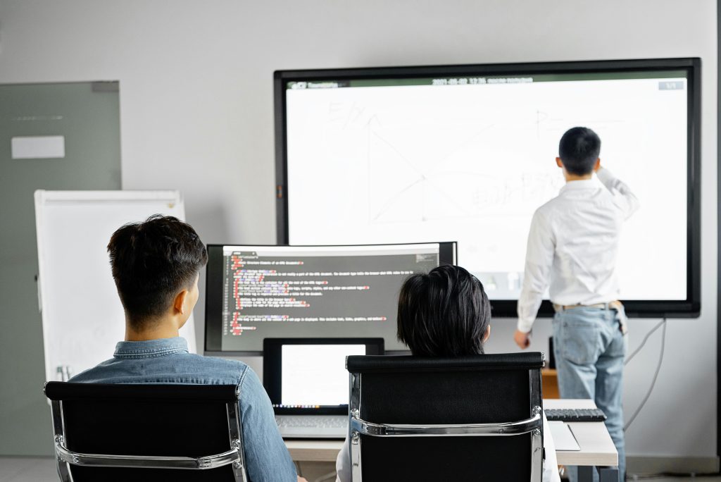 Instructor leading a hands-on software training session for a team learning to do the work in-house